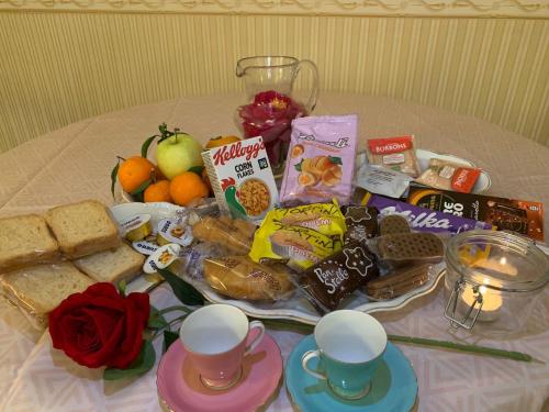 una mesa con una bandeja de alimentos y tazas para el desayuno en Domus Diocleziano, en Nápoles