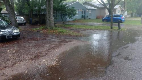 a puddle of water on a street with a car at Lenny's Cooperative Hostel in Clearwater