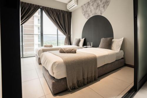 two beds in a bedroom with a large window at K Avenue by CAIRO in Donggongon