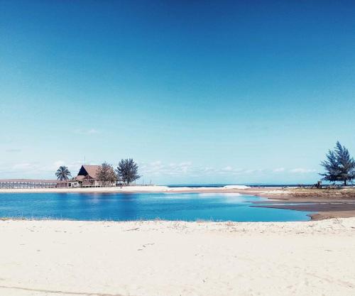 una spiaggia con una casa in lontananza e l'oceano di Barra house a Inhambane
