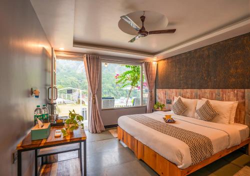 a bedroom with a large bed and a window at Moustache Rishikesh Riverside Resort in Rishīkesh