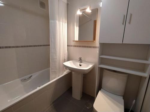 a white bathroom with a sink and a toilet at Apartamento en Astillero con plaza de aparcamiento in El Astillero