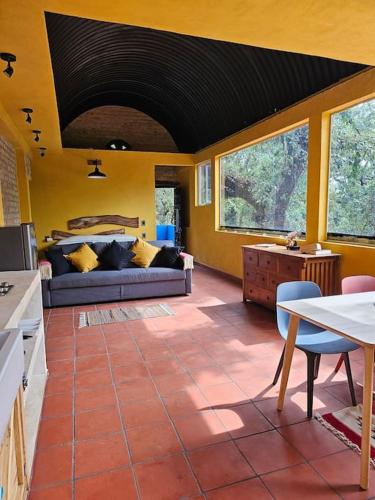 a living room with a couch and a table at La Cabaña Negra al fondo del Bosque de Tepoztlán in Tepoztlán