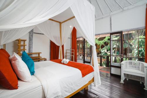 a bedroom with a white bed with a canopy at Villa Pagoda, Sumptuous 4BR Villa with Tropical Vibes in Seminyak in Legian