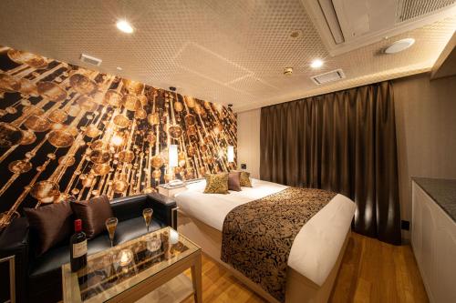Habitación de hotel con cama y pared con copas de vino en ホテル継kei男塾ホテルグループ, en Himeji