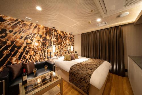 a hotel room with a bed and a wall with wine glasses at ホテル継kei男塾ホテルグループ in Himeji