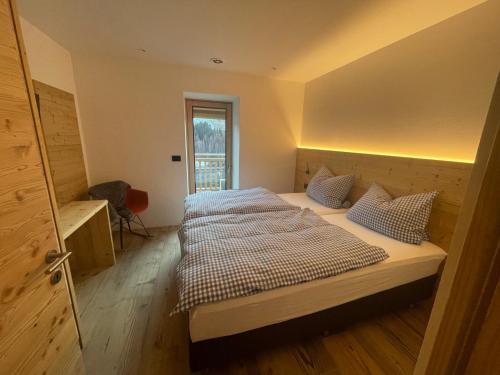 una camera da letto con un grande letto con cuscini sopra di Appart-Chalet con vista sulla Litegosa a Panchia