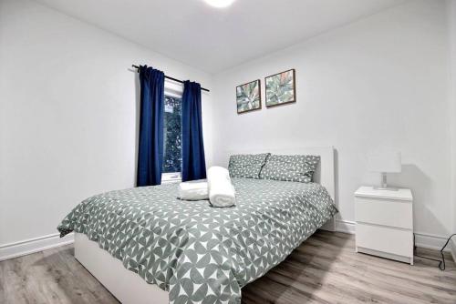 a white bedroom with a bed and a window at Luxury home by Tim Hortons Field in Hamilton