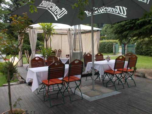 a table and chairs sitting under an umbrella at Romantik Hotel Zum Lindengarten in Kurort Jonsdorf