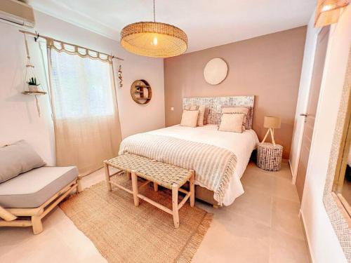 a bedroom with a bed and a chair and a window at Dolce Riviera, Beach Access, Pool View, 2 Bedrooms in Anse Marcel 