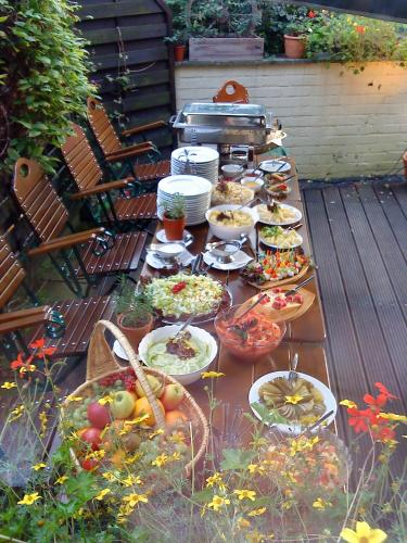 a long table with many plates of food on a patio at Romantik Hotel Zum Lindengarten in Kurort Jonsdorf