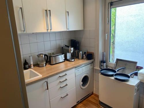a kitchen with a sink and a washing machine at Wohlfühlen in Winterhude in Hamburg