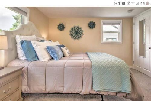 a bedroom with a large bed with blue and white pillows at Tranquil Cottage Walk Downtown in Great Falls