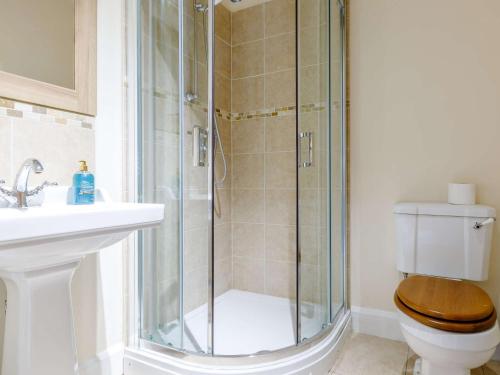 a bathroom with a shower with a toilet and a sink at 3 Bed in Sherborne 65854 in Pointington