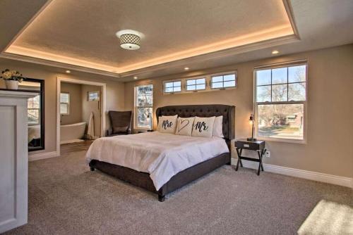 een slaapkamer met een groot bed in een kamer met ramen bij Spacious Home With Hot Tub in Great Falls