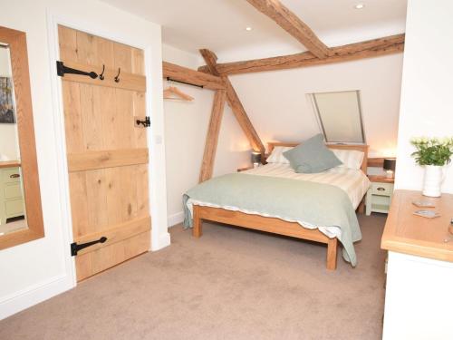 a bedroom with a bed and a wooden door at 3 Bed in Fordingbridge 66130 in Redlynch