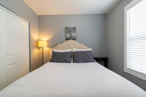 Un dormitorio con una gran cama blanca con dos almohadas. en Cozy Great Falls Retreat., en Great Falls