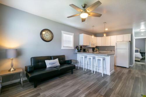Una sala de estar con un sofá negro y una cocina. en Cozy Great Falls Retreat., en Great Falls
