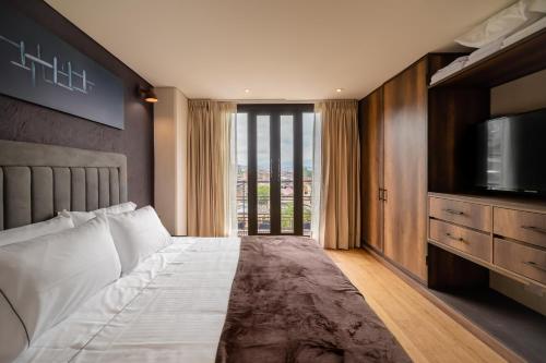 um quarto com uma cama com uma televisão e uma cama sidx sidx em Morph Candelaria em Bogotá