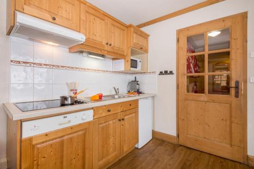 une cuisine avec des armoires en bois et un évier dans l'établissement Appartement Anaïte 15 - Happy Rentals, aux Houches
