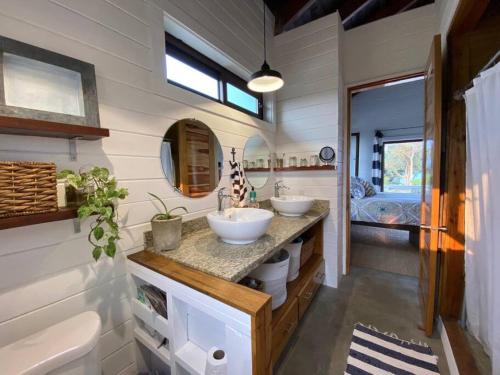 uma casa de banho com dois lavatórios numa pequena casa em La Vida Belize - Casa em Riversdale