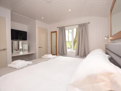 ein weißes Schlafzimmer mit einem großen Bett und einem Fenster in der Unterkunft 1 Bed in Langbank 73846 in Langbank