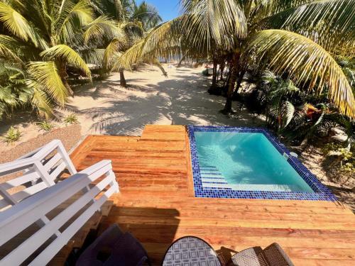 a swimming pool on a wooden deck next to a beach at La Vida Belize - Casita in Riversdale