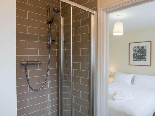 a shower with a glass door next to a bed at 3 Bed in Camber BT044 in Camber