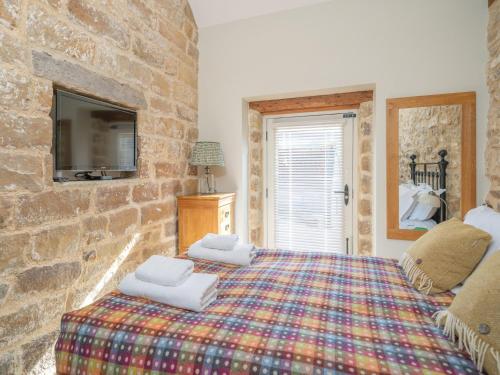 a bedroom with a king sized bed in a stone wall at 2 Bed in North York Moors National Park G0132 in Rosedale Abbey