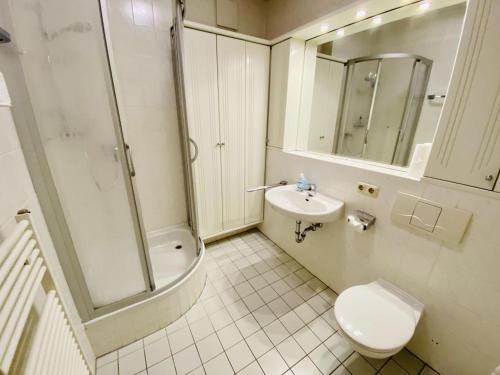 La salle de bains est pourvue de toilettes, d'un lavabo et d'une douche. dans l'établissement Seaside, direkt an der Promenade, à Warnemünde