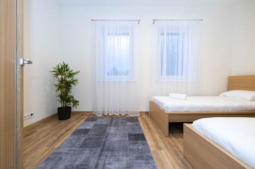 1 dormitorio con 2 camas y una maceta en Eglių Apt W/Terrace, By Cohost en Palanga