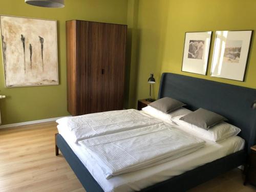 een groot bed in een slaapkamer met groene muren bij Villa Minerva Ostwind in Warnemünde