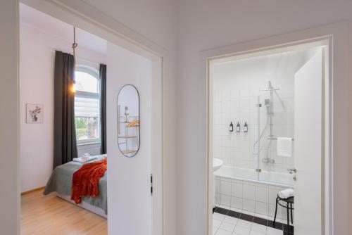 uma casa de banho branca com uma banheira e um lavatório em Stilvoll & historisch I Kingbetten+Küche+Parkplatz em Wesel