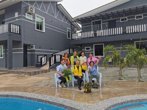 a group of people sitting in chairs in front of a house at Perry Barr La Ganta Residence in Temerloh