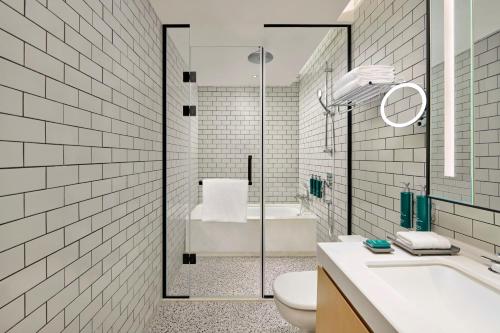 a bathroom with a tub and a toilet and a sink at Doubletree By Hilton Shenzhen Airport Residences in Shenzhen
