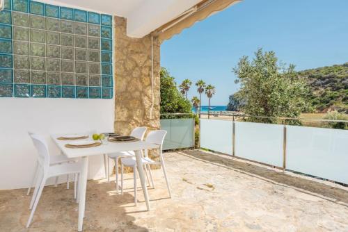 a white table and chairs on a balcony with the ocean at 4Brothers in Cala'n Porter
