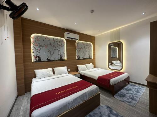 a hotel room with two beds and a mirror at OYO 1219 Thien Han Phat Hotel in Da Nang