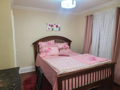 - une chambre avec un lit doté de draps et d'oreillers roses dans l'établissement 3 BR House in Toronto Downtown, à Toronto