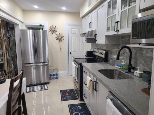 a kitchen with white cabinets and a stainless steel refrigerator at 3 BR House in Toronto Downtown in Toronto