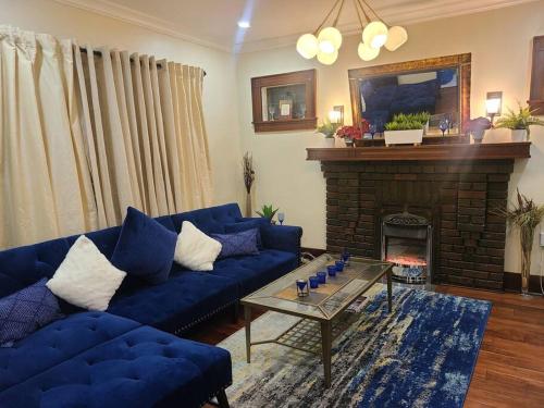 a living room with blue couches and a fireplace at 3 BR House in Toronto Downtown in Toronto