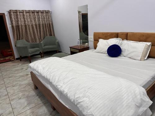 Un dormitorio con una cama grande con una almohada azul. en Garden Villa hotel, en Ujjain