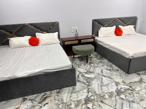1 dormitorio con 2 camas, escritorio y silla en Garden Villa hotel, en Ujjain