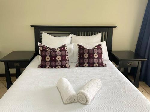 uma cama com almofadas e toalhas em Sombedu guest suite em Margate