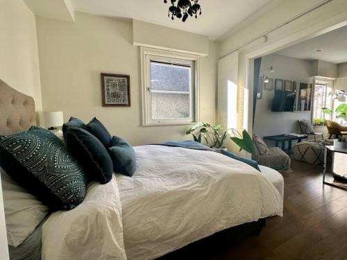 Un dormitorio con una cama grande con almohadas. en Mosaic Suite at The Inn On The Drive, en Vancouver