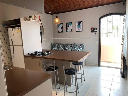 a kitchen with a counter and stools in it at Studio Residencial Curitiba Apartament in Curitiba