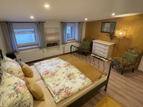 a bedroom with a bed and a dresser and chairs at NEU! Ferienwohnung Ostseebeere in Groß Zastrow