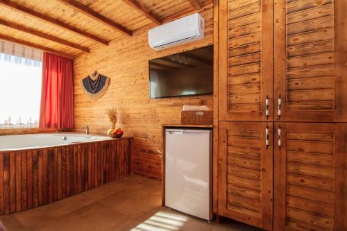 a kitchen with wooden cabinets and a white refrigerator at Ölüdeniz Manzara Non Alcoholic Family Hotel in Oludeniz