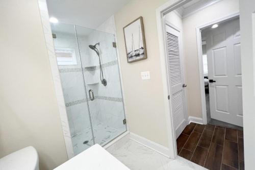 a bathroom with a shower with a glass door at The Traveler - Your Private Retreat, Inspired by the Spirit of Travel in Manassas Park