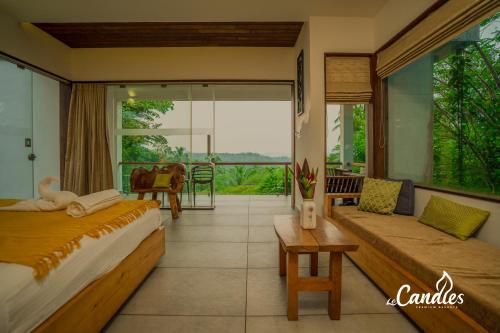 a hotel room with two beds and a balcony at Le Candles Resort in Kozhikode