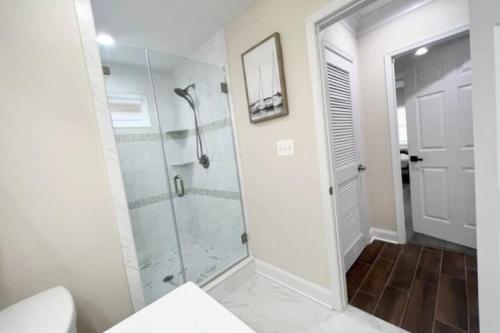 a bathroom with a shower with a glass door at The Beach Pad - Your Private Oasis with a Cool Beachy Vibe in Manassas Park
